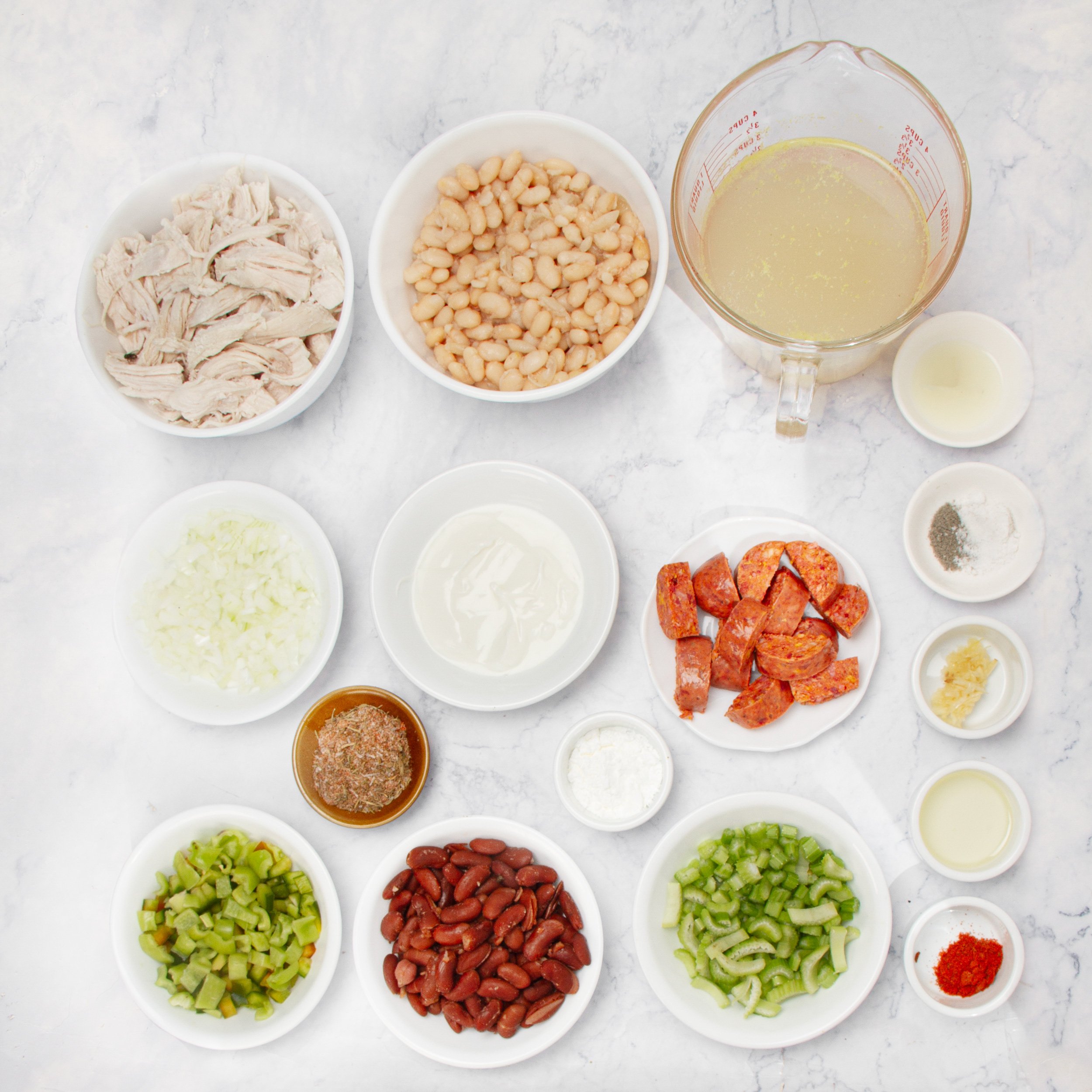 Cajun white chicken chili ingredients in separate dishes on a countertop.