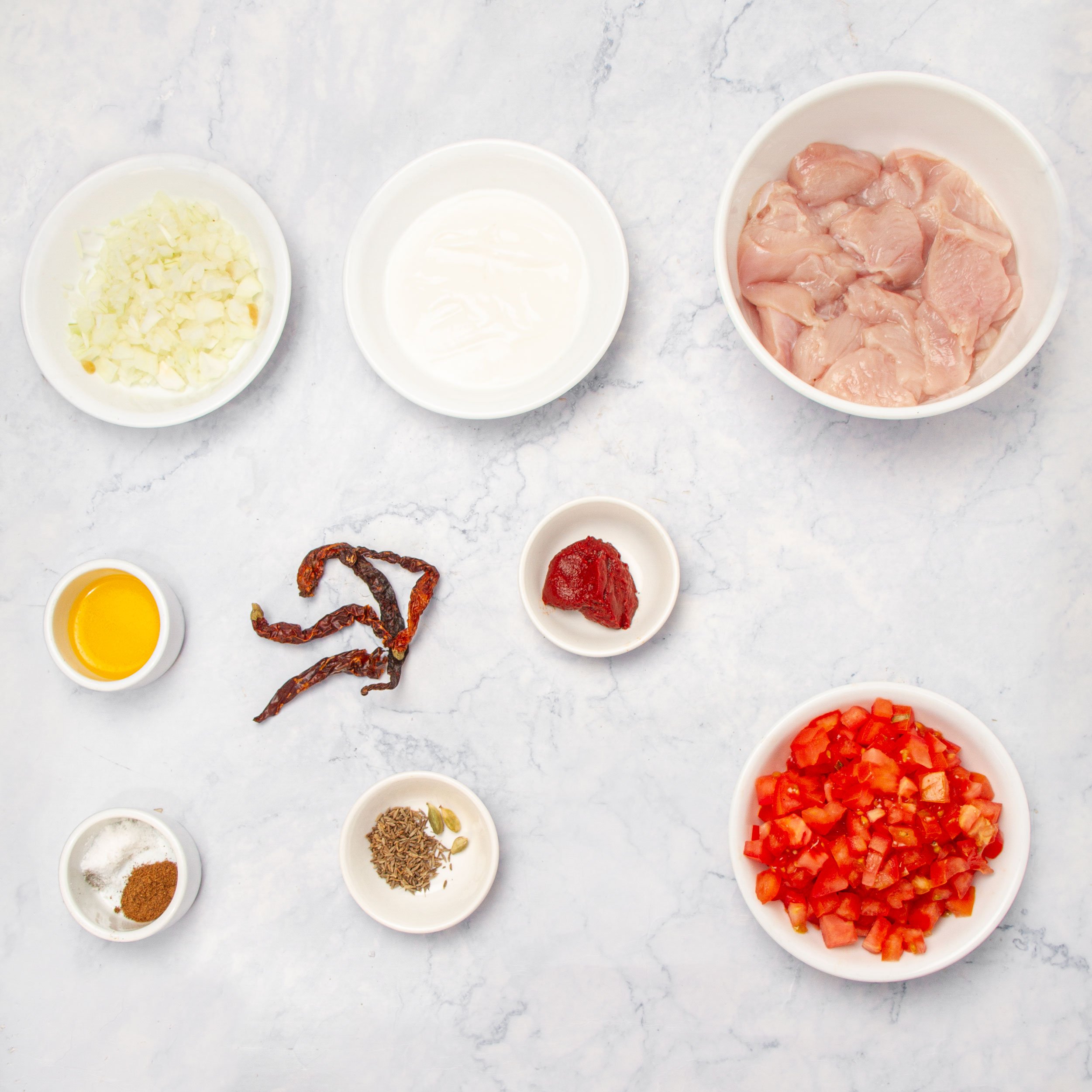 Ingredients for chicken rogan josh in separate dishes. 