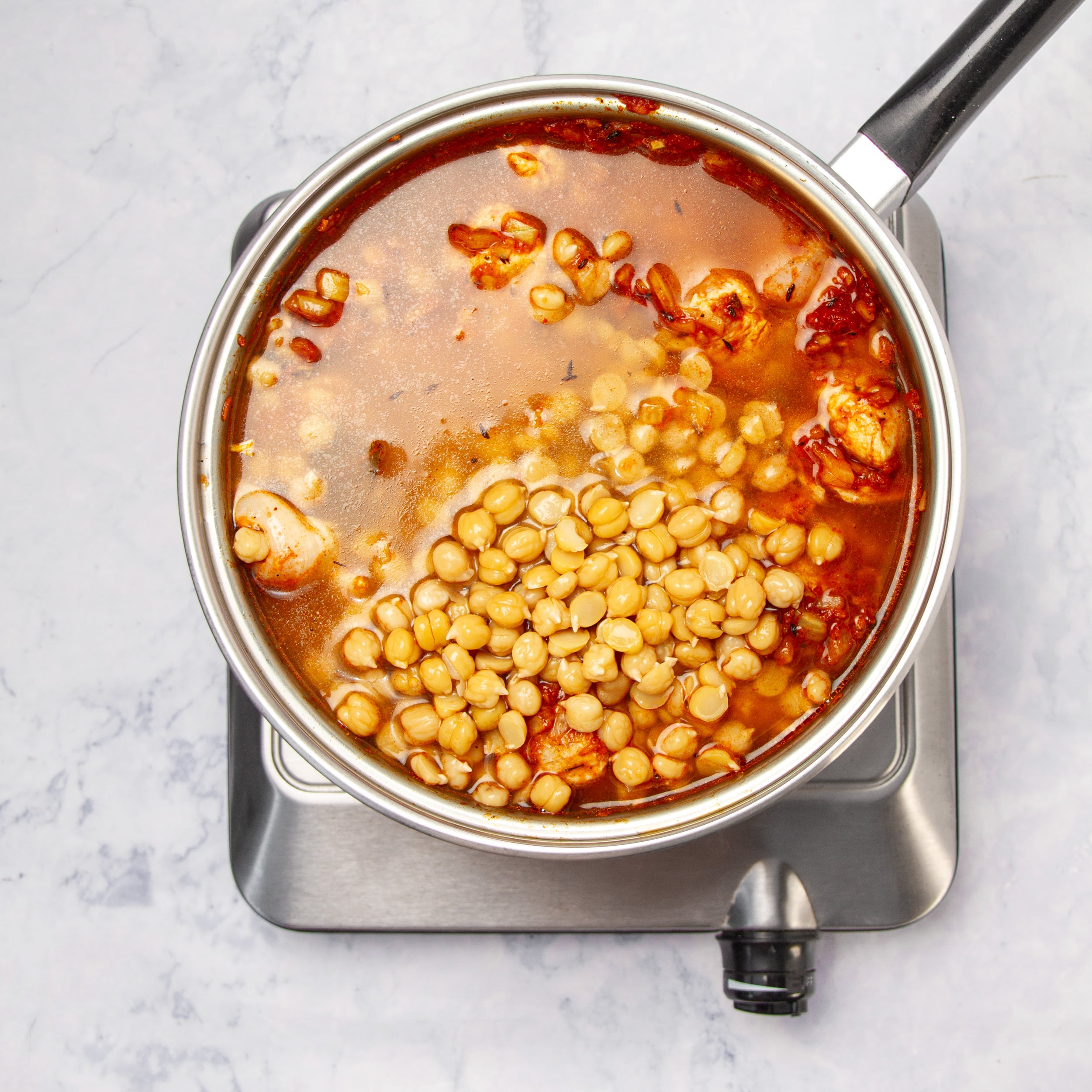 Chickpeas and chicken added to the pan of sauce. 