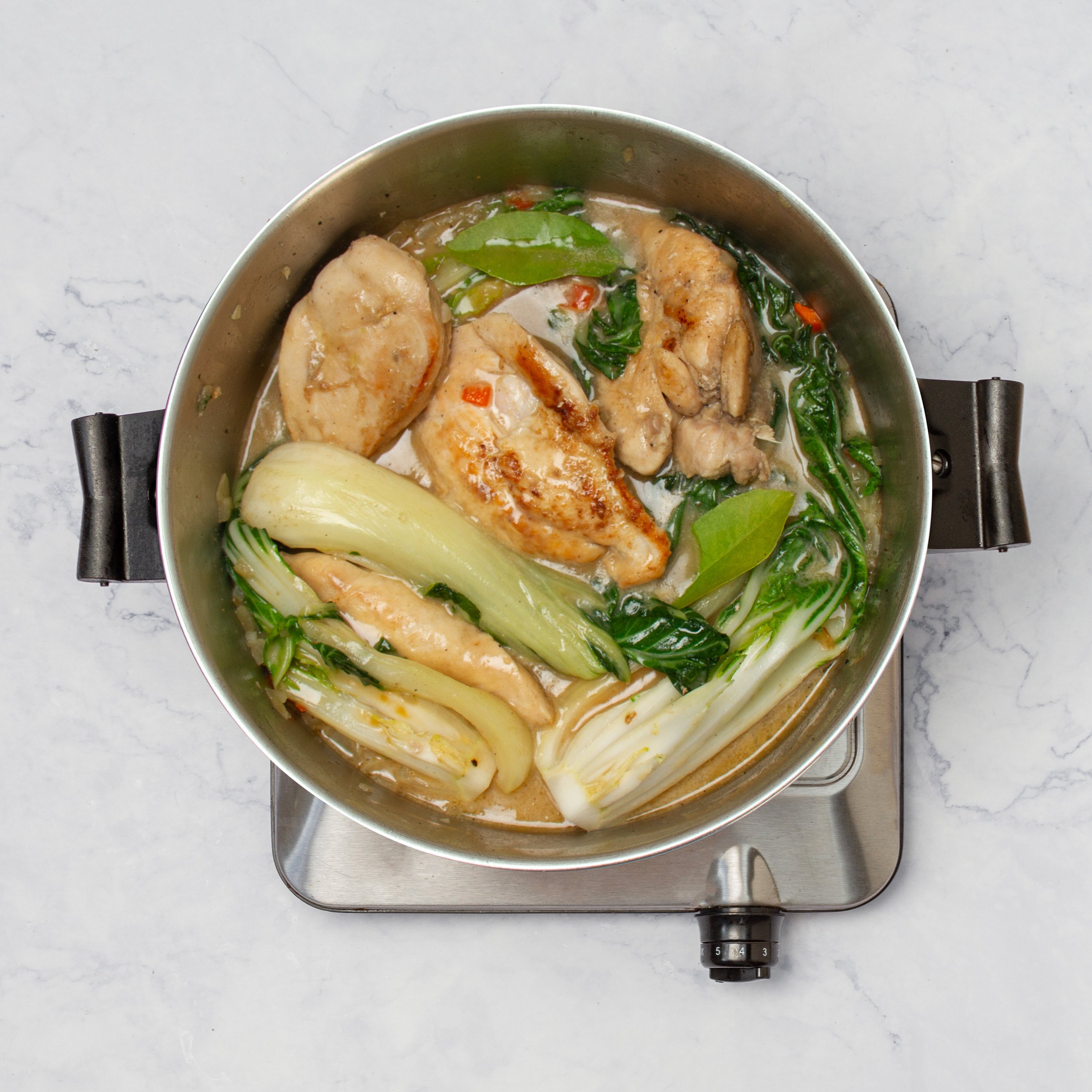 Chicken and bok choy simmering in the sauce.